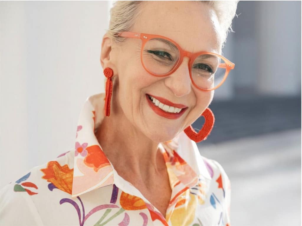 Porträt einer Frau Ü50 mit schöner Brille in orange, passend zum Typ und zur Kleidung