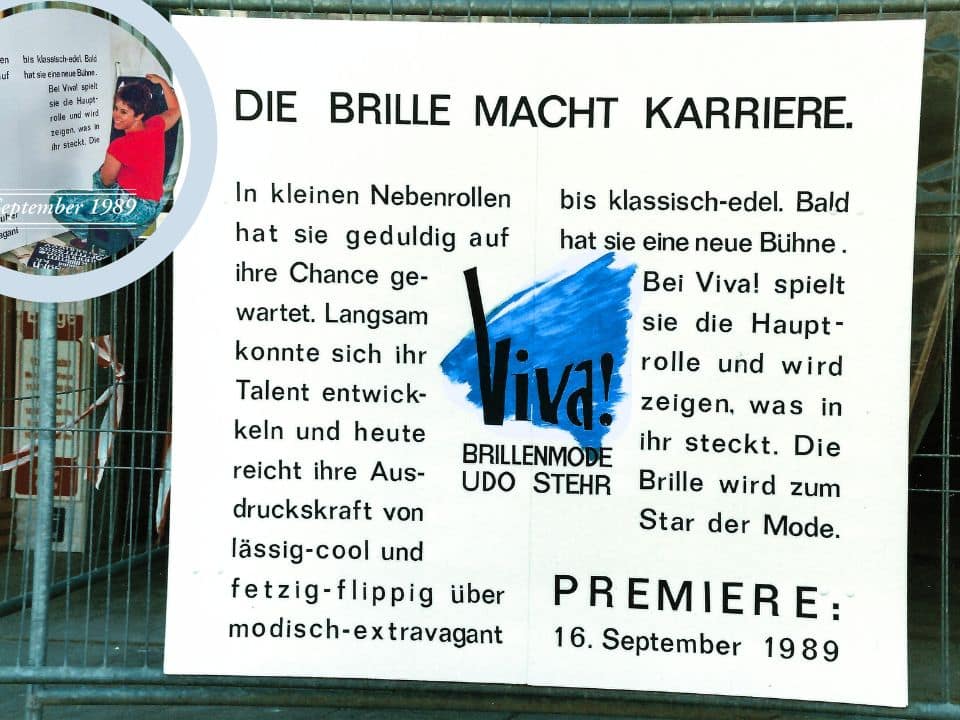 Karin Stehr beklebt ein Bauschild zur Neueröffnung von Viva! Brillenmode 1989